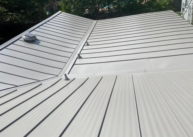 Solar attic fan installed on a metal roof for Roof Ventilation in Grand Rapids